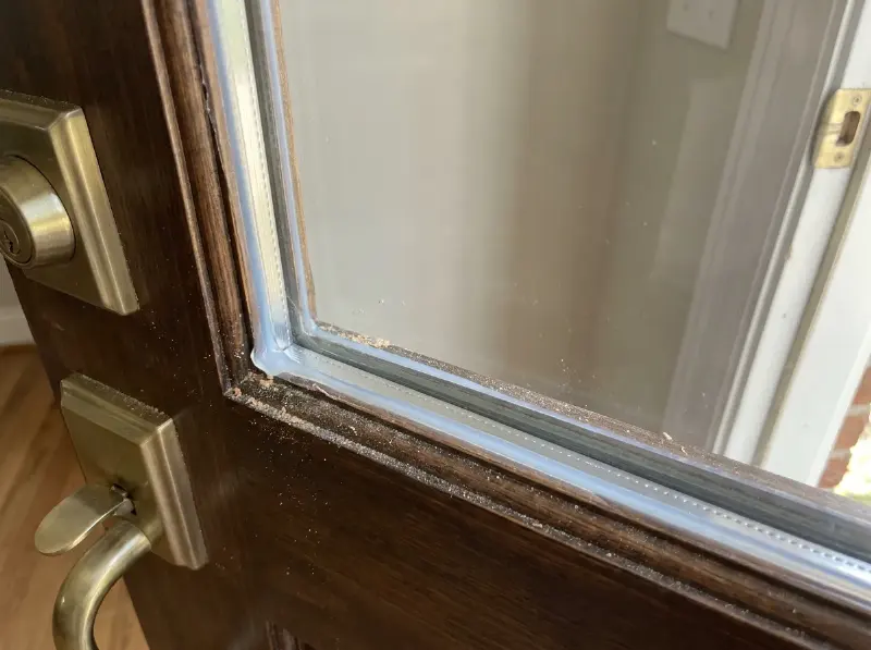 Voordeur met een nieuwe ruit in gelaagd veiligheidsglas, kitnaad pas aangebracht